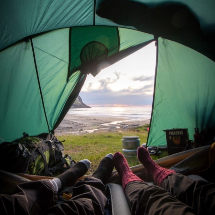 People enjoying a great view from their tent at a campsite
