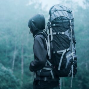 Young person carrying a backpack while exploring the outdoor lifestyle